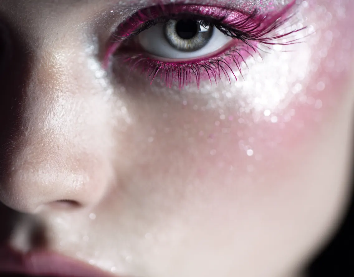 Close-up of an eye with shimmering pink esthetics makeup